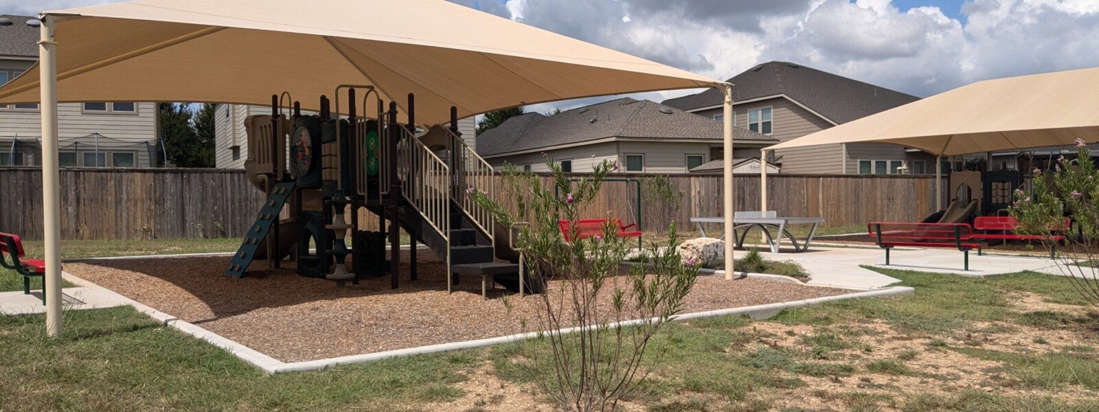 Playgrounds under shade structures, with park benches nearby.